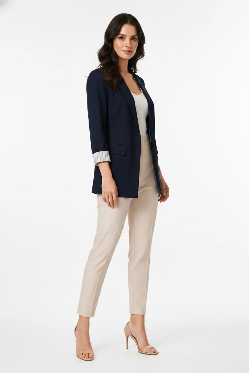Navy blue longline cuffed blazer on a model in a three-quarter turn pose