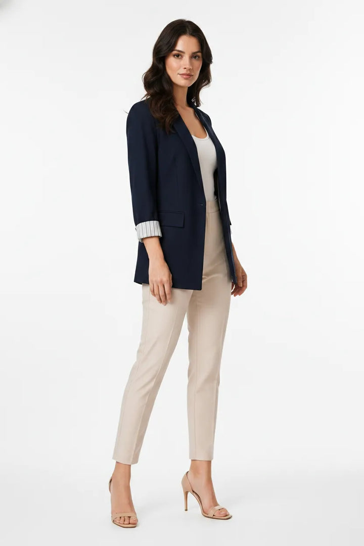 Navy blue longline cuffed blazer on a model in a three-quarter turn pose