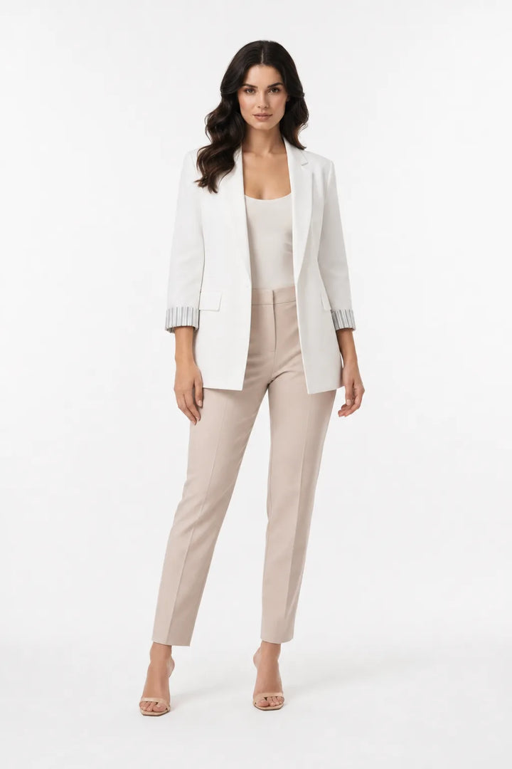 White longline blazer with cuffed sleeves on a model in a contrapposto stance