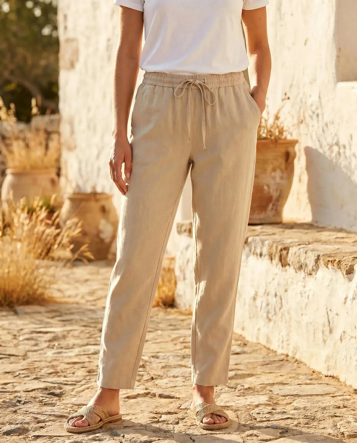 Beige drawstring tapered pants on model at three-quarter turn showing fit and silhouette