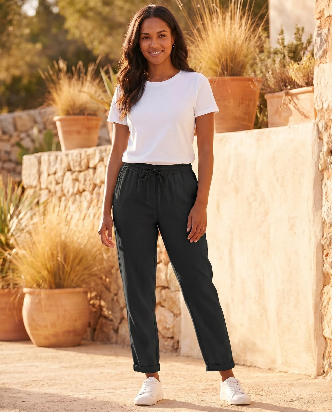Beige drawstring tapered pants on model in a clean full-length standing pose