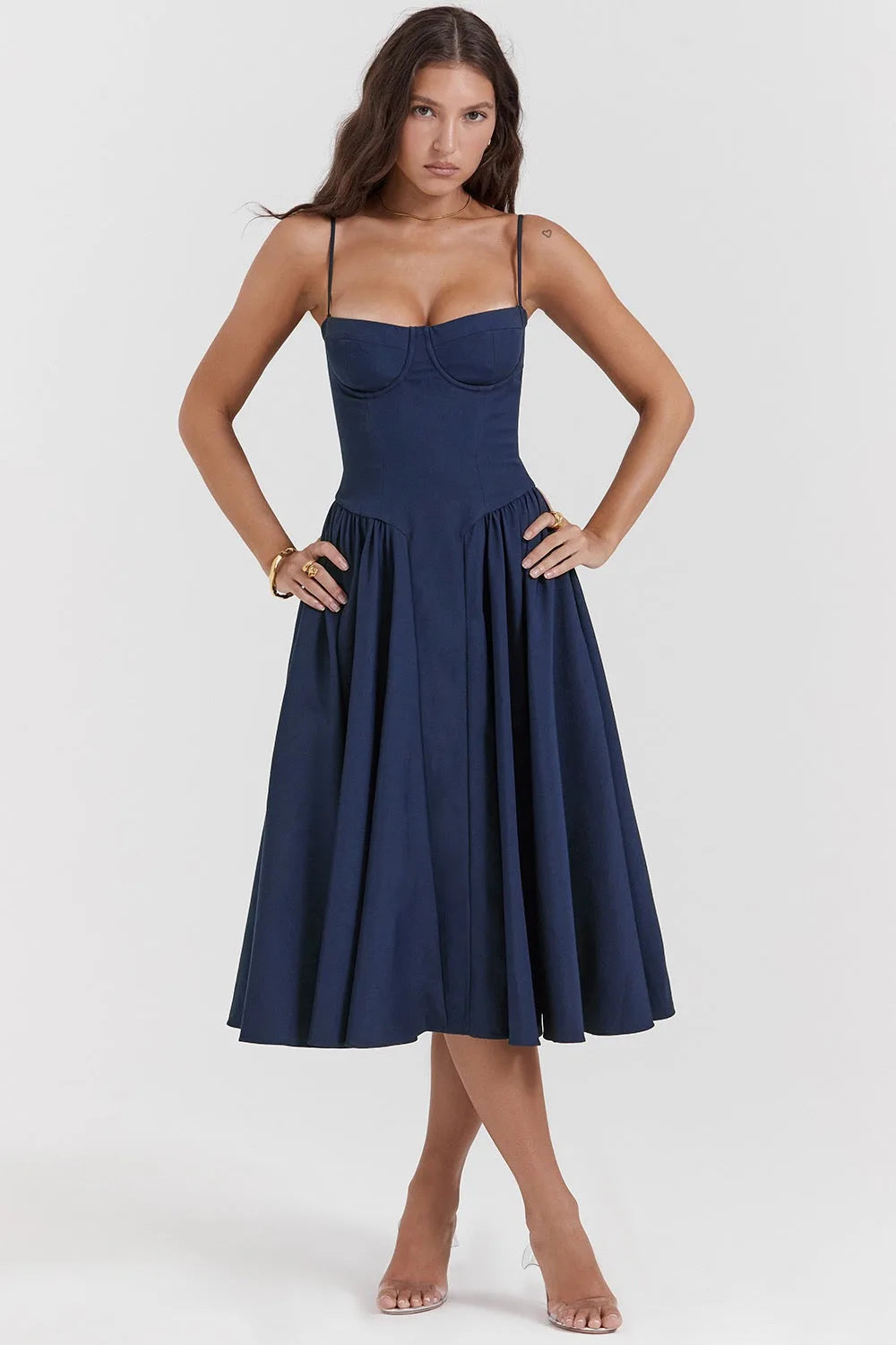 Model in side profile wearing a navy blue corset midi dress with fitted waist