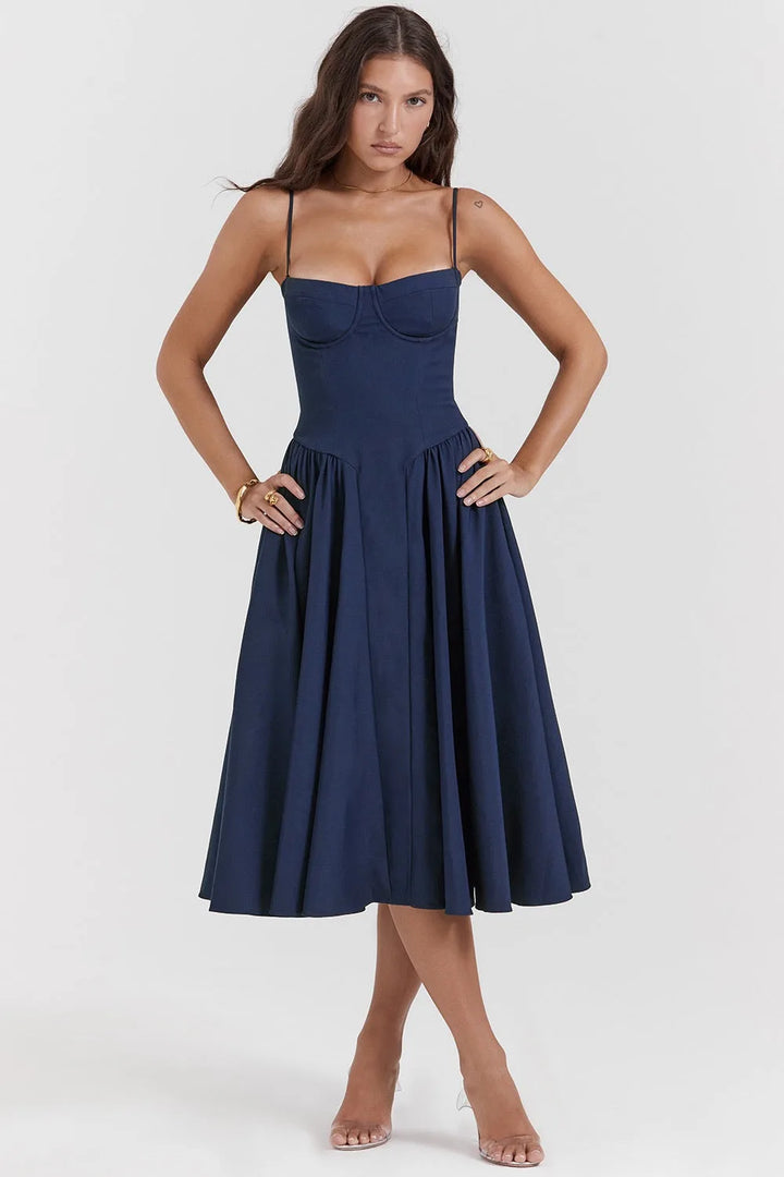 Model in side profile wearing a navy blue corset midi dress with fitted waist