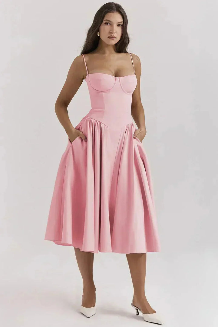 Model wearing a pink corset midi dress with structured corset bodice and midi-length skirt