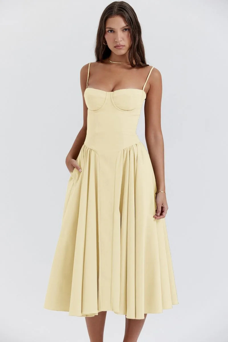 Model facing forward in a yellow corset midi dress with structured bodice and flowing skirt