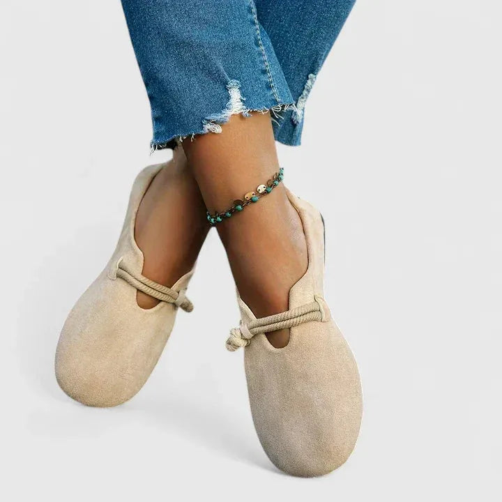 Close-up detail of rope tie closure on beige flat sandal