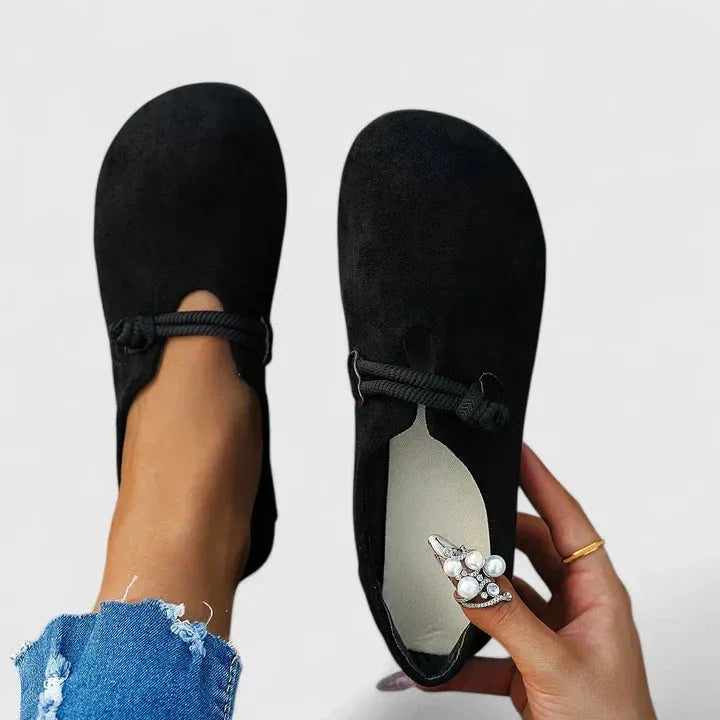 Black rope-tie flat sandal, heel view