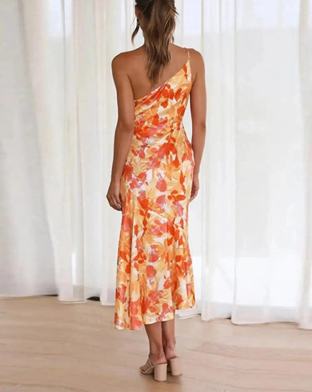 Additional view of model wearing an orange floral one-shoulder midi dress