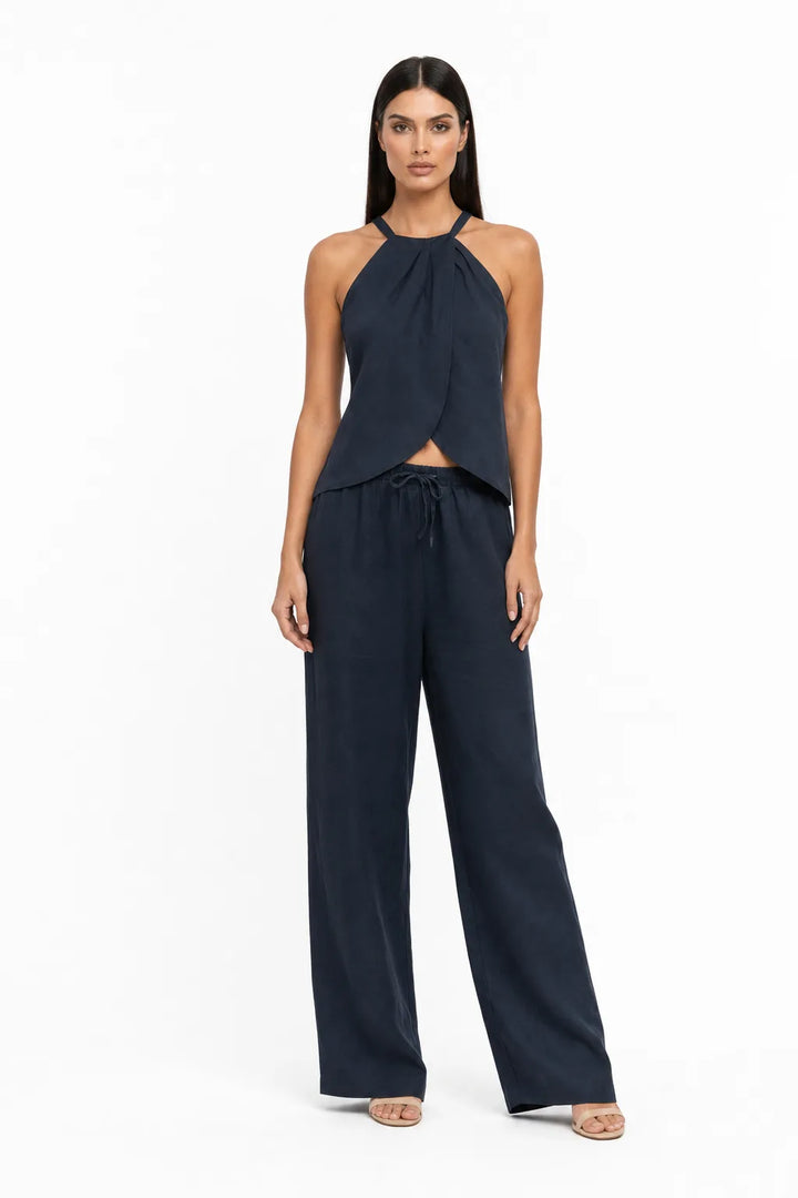 Dark blue halter wrap crop top and skirt two-piece set on model in contrapposto stance