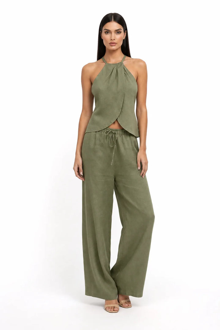 Green halter wrap crop top and skirt two-piece set on model in contrapposto stance