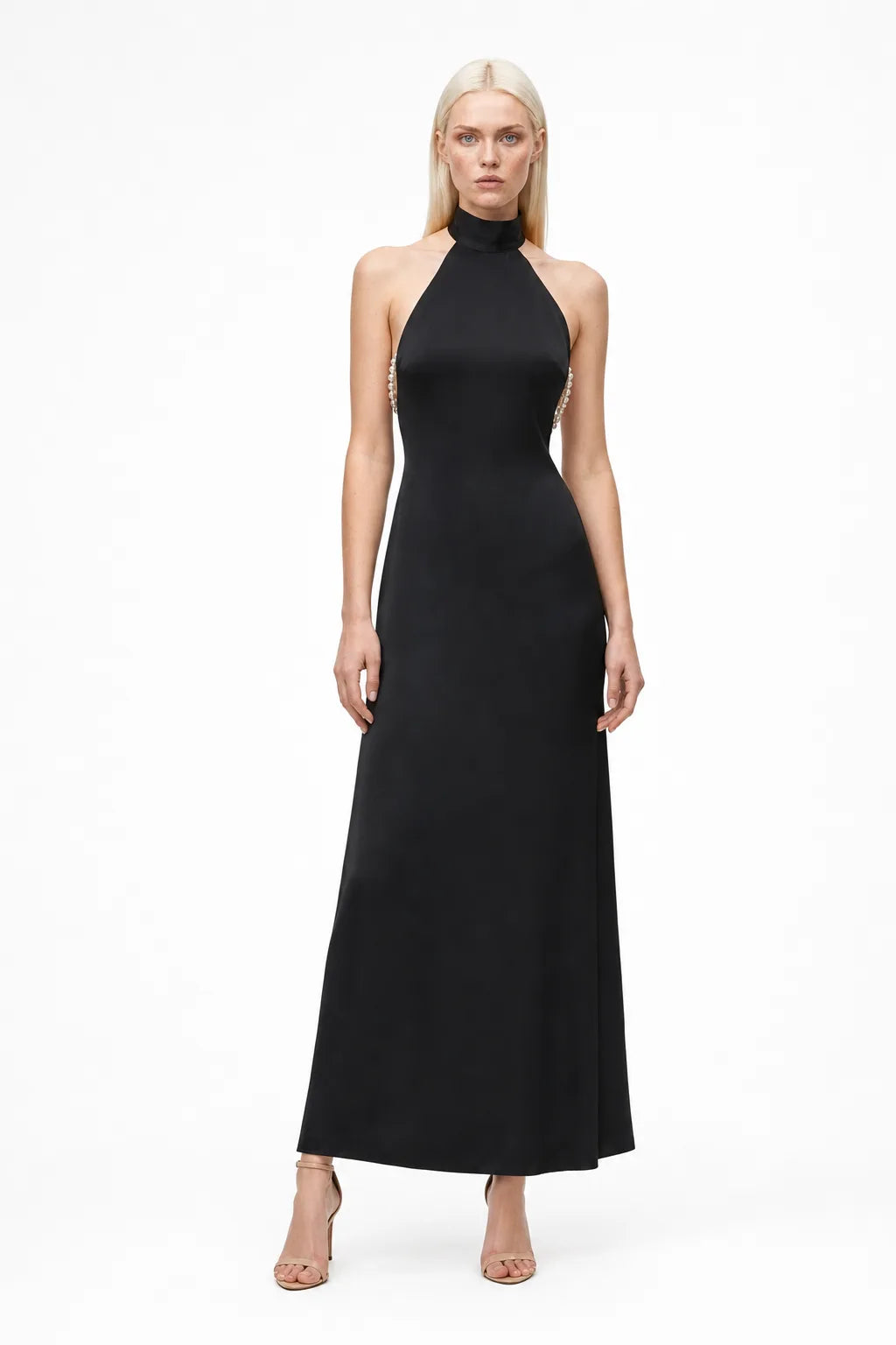 Black halter gown with pearl back detail, model in contrapposto stance