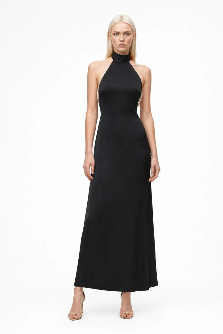 Black halter gown with pearl back detail, model in contrapposto stance