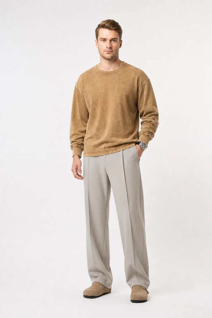 Khaki pleated wide-leg trousers on a model in a contrapposto stance