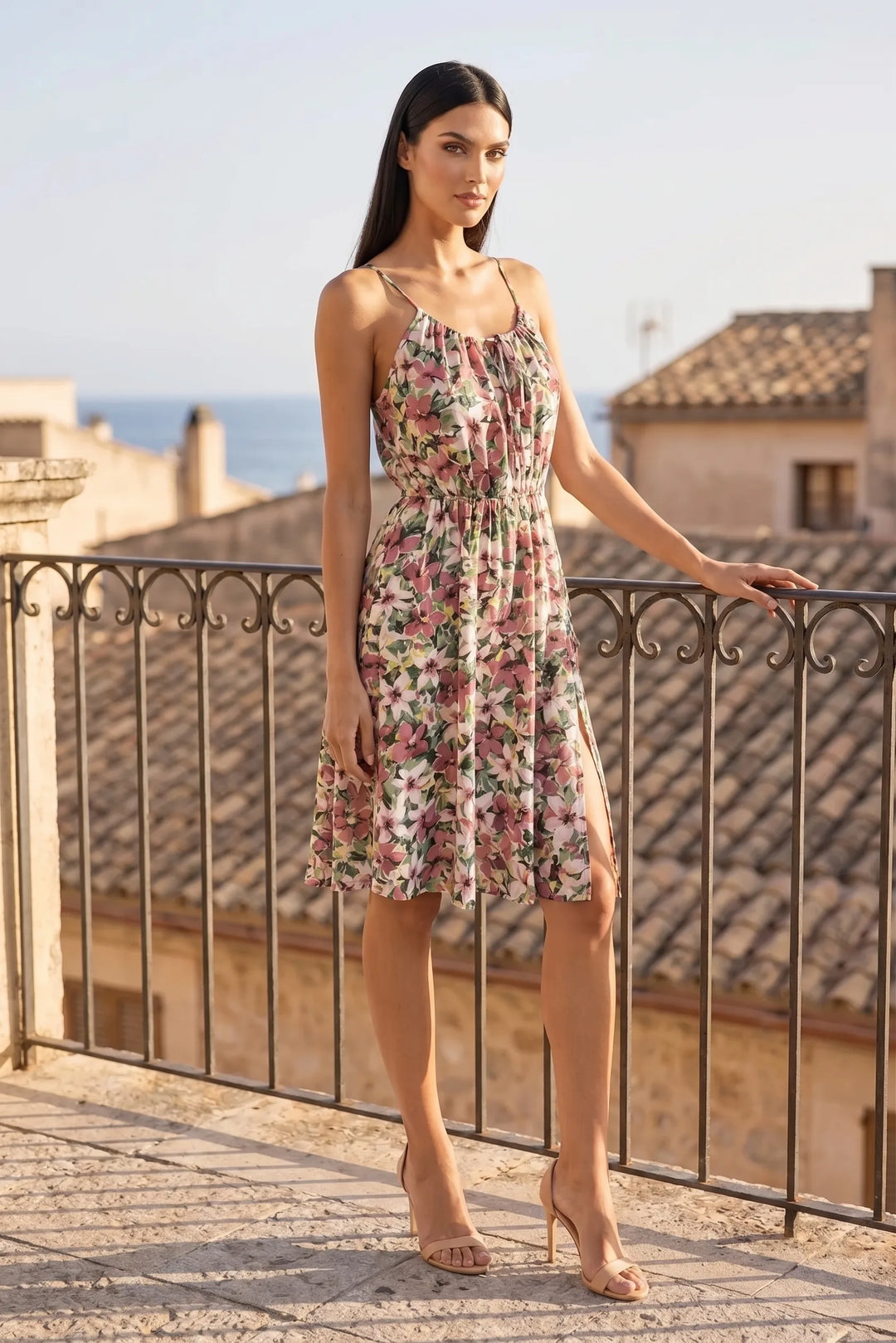 Model wearing pink floral halter sundress in outdoor lifestyle setting