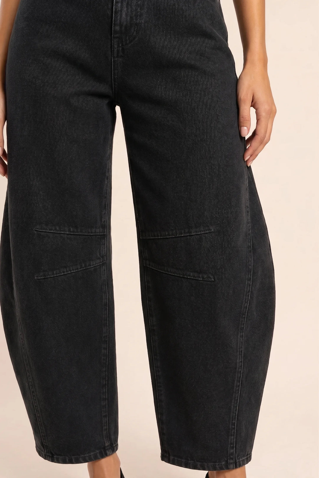 Close-up detail of black barrel leg jeans