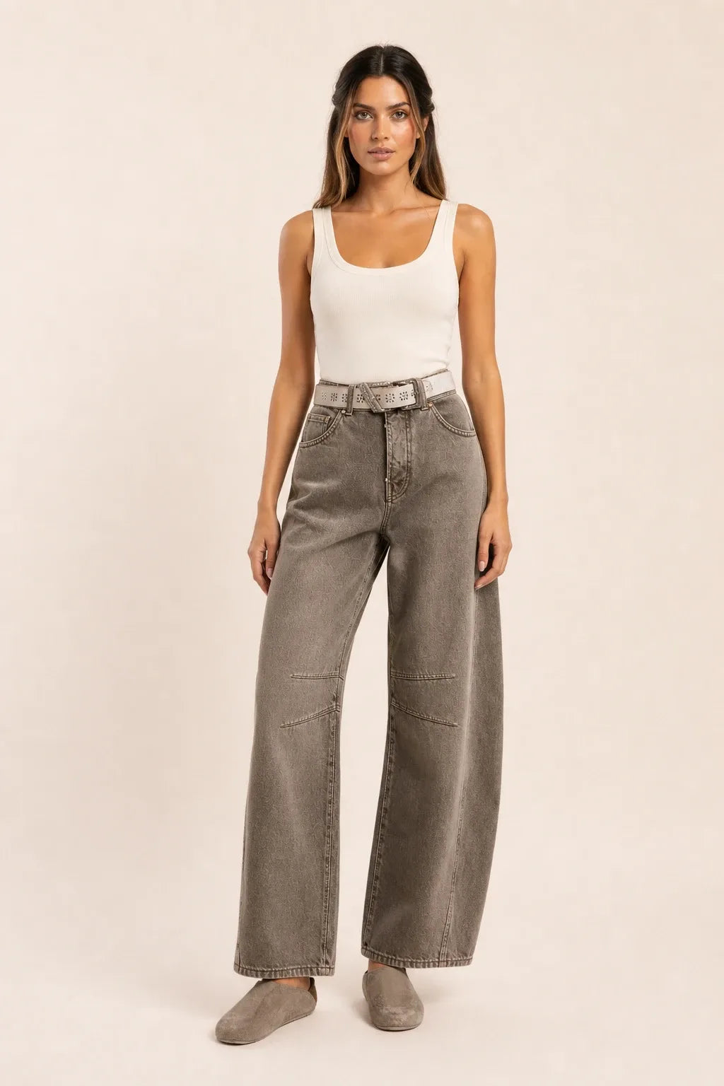 Grey barrel leg jeans on a model standing in a contrapposto pose