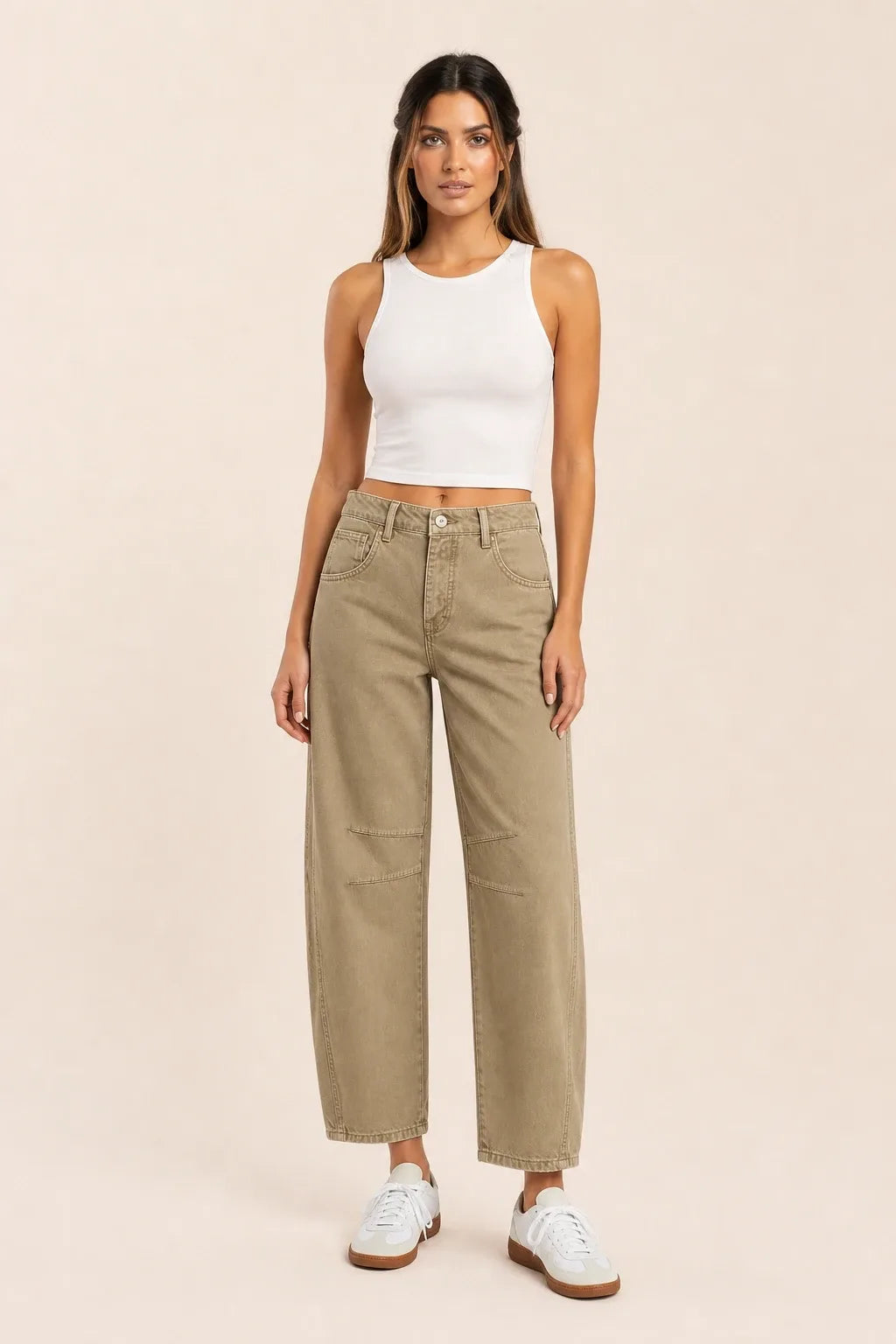 Khaki barrel leg jeans on a model standing in a contrapposto pose