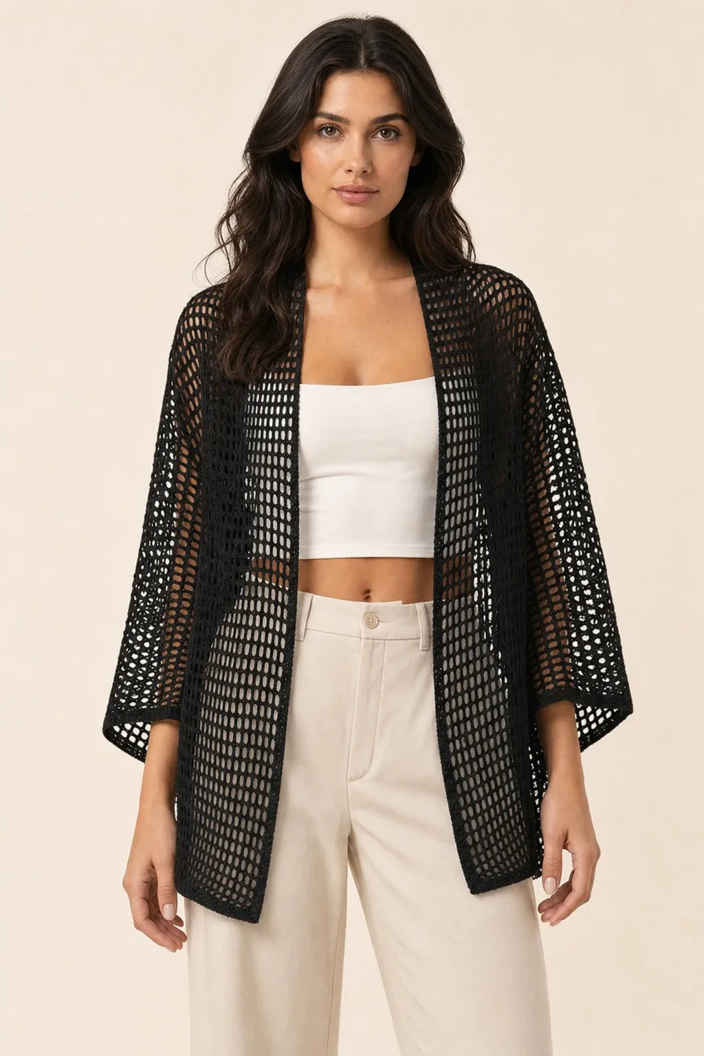 Black net knit open-weave cardigan on model in contrapposto stance