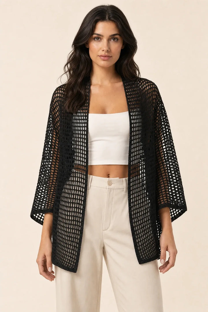 Black net knit open-weave cardigan on model in contrapposto stance