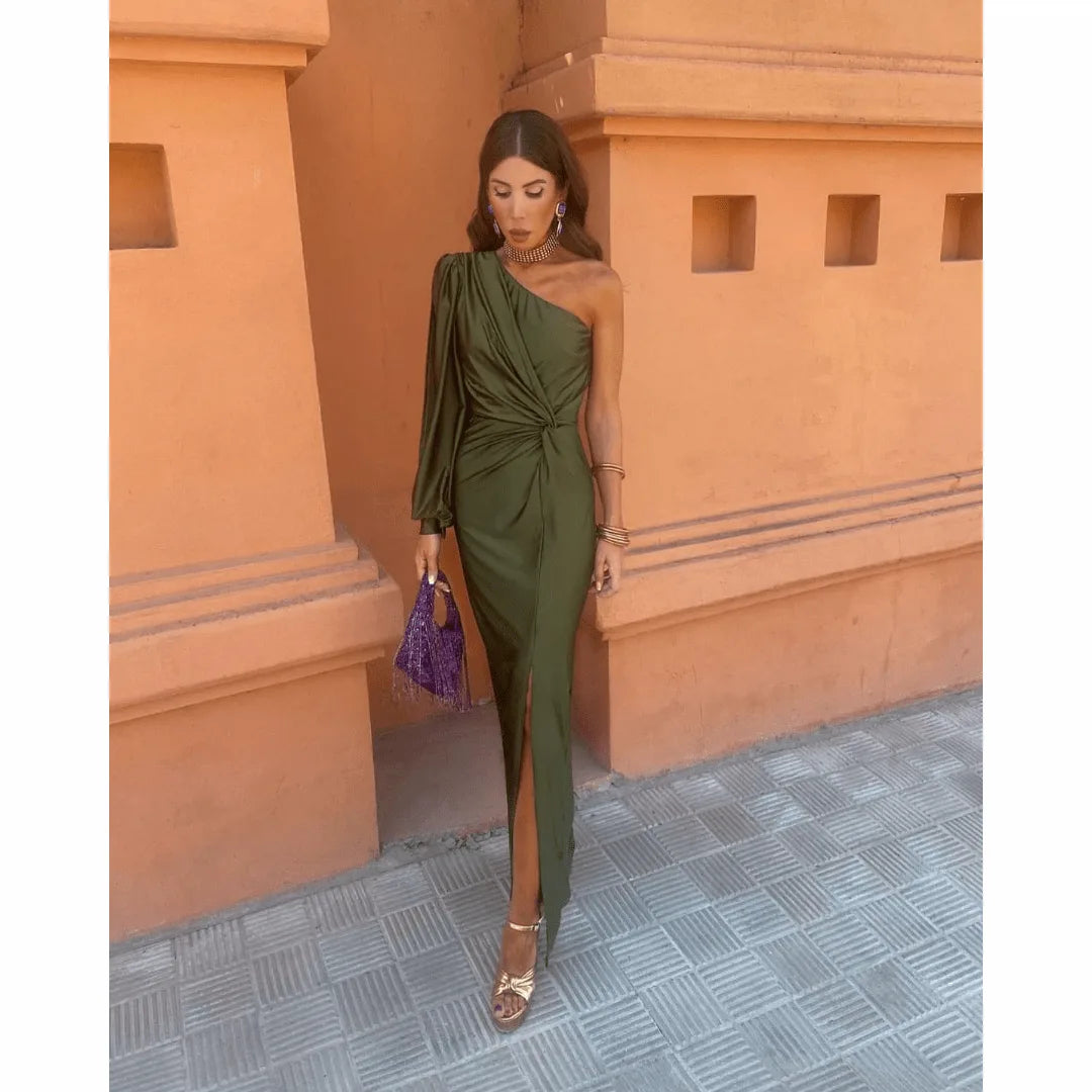 Woman facing forward in an olive green one-shoulder twist maxi dress with a floor-length skirt