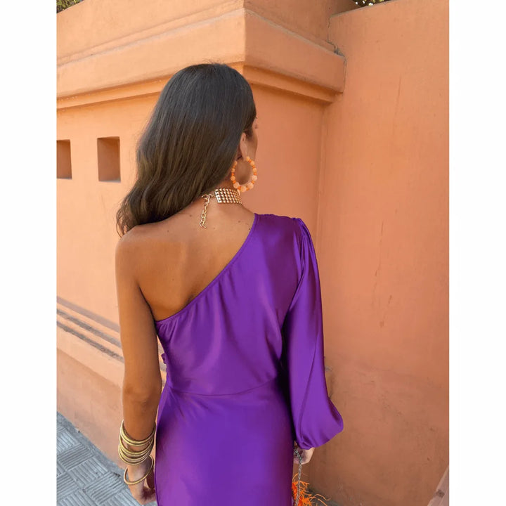 Woman in an olive green one-shoulder twist maxi dress shown from an alternate angle