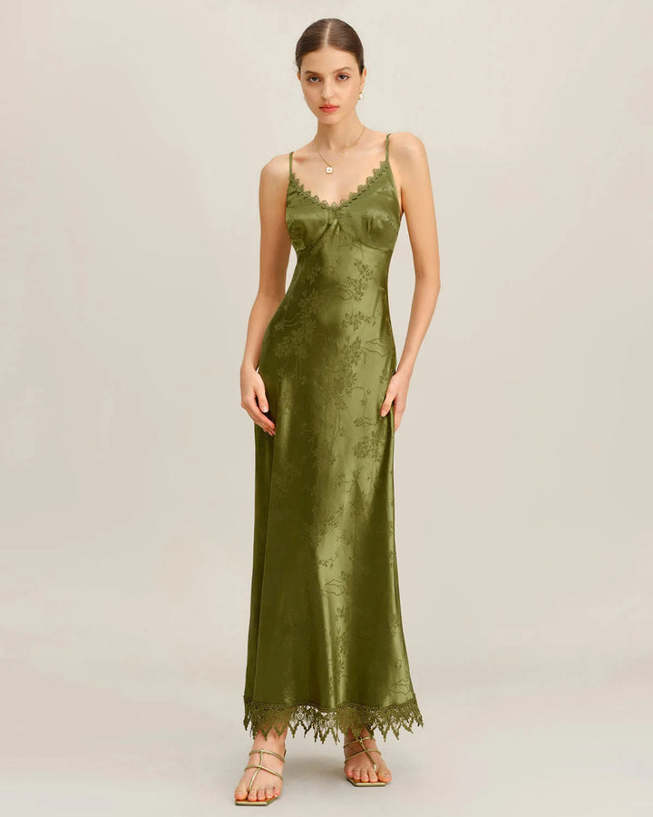 Model posing in a green lace-up jacquard maxi dress with full-length silhouette