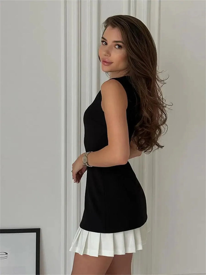 Woman at a three-quarter angle wearing a black pleated hem mini skirt