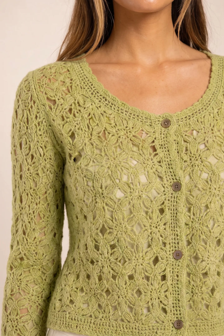 Close-up detail of green crochet scallop cardigan texture and hem