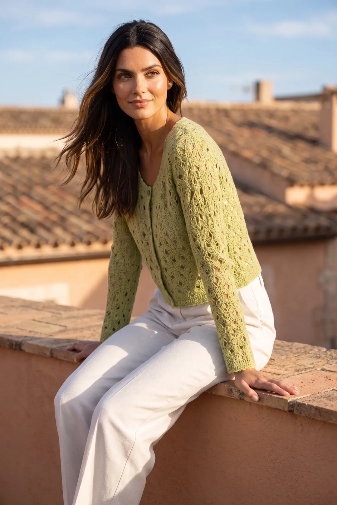 Model wearing green crochet scallop cardigan in outdoor lifestyle setting