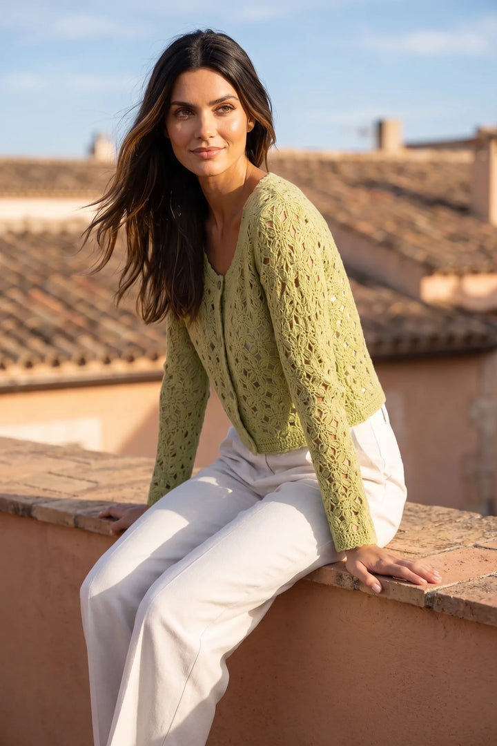 Model wearing green crochet scallop cardigan in outdoor lifestyle setting