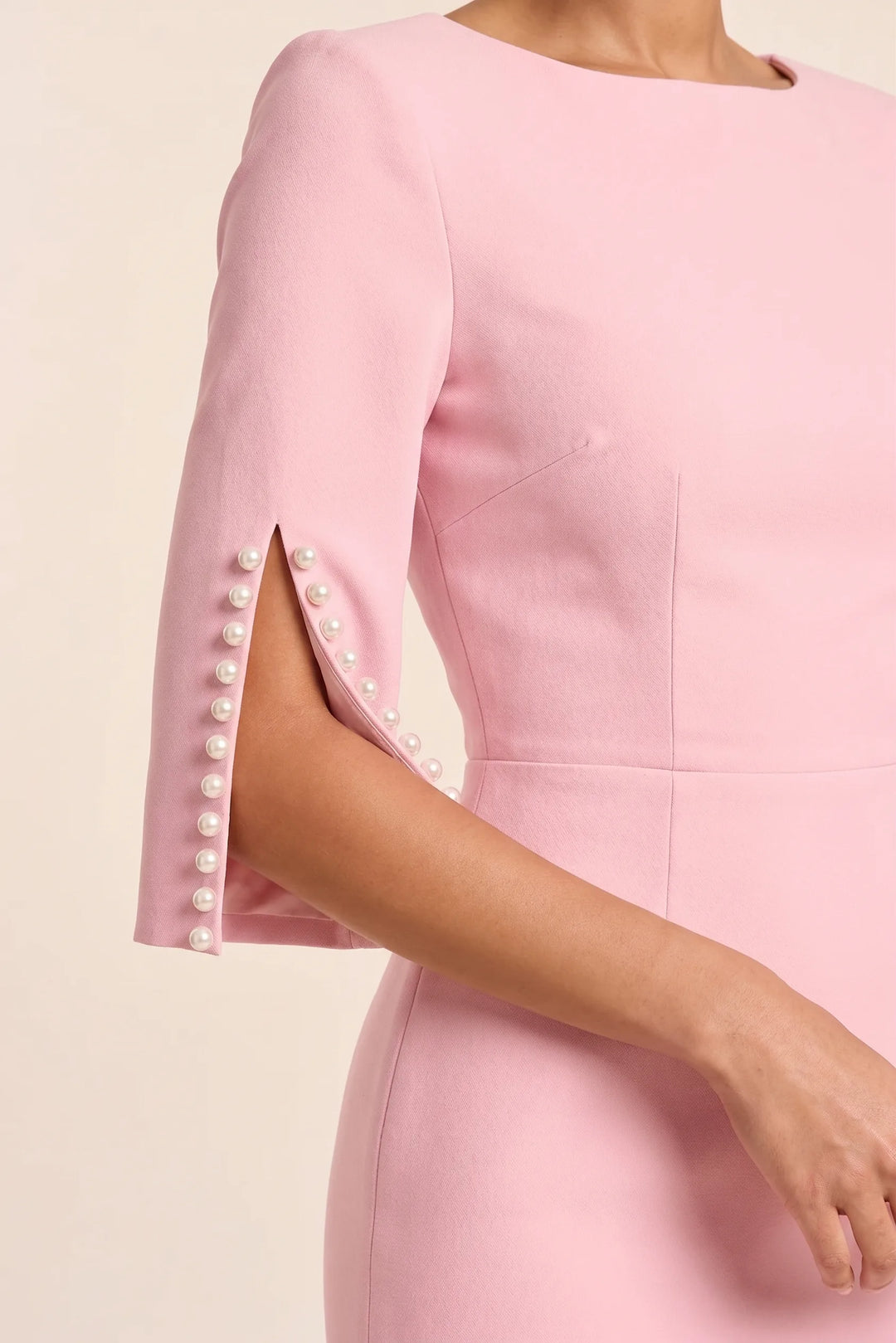 Close-up detail of pearl trim and split sleeve on a pink midi dress