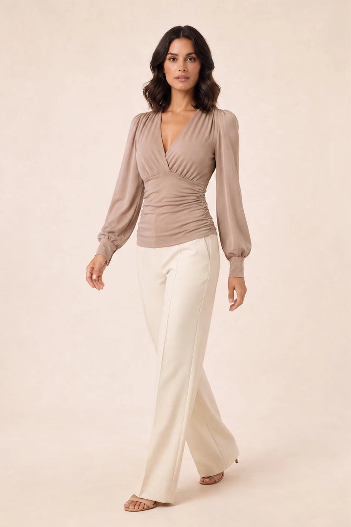 Khaki ruched wrap blouse on model in three-quarter turn, showing side silhouette and wrap tie