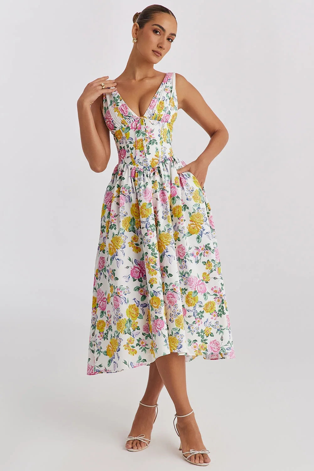Model facing forward in a yellow floral corset midi dress with structured bodice and flowing skirt