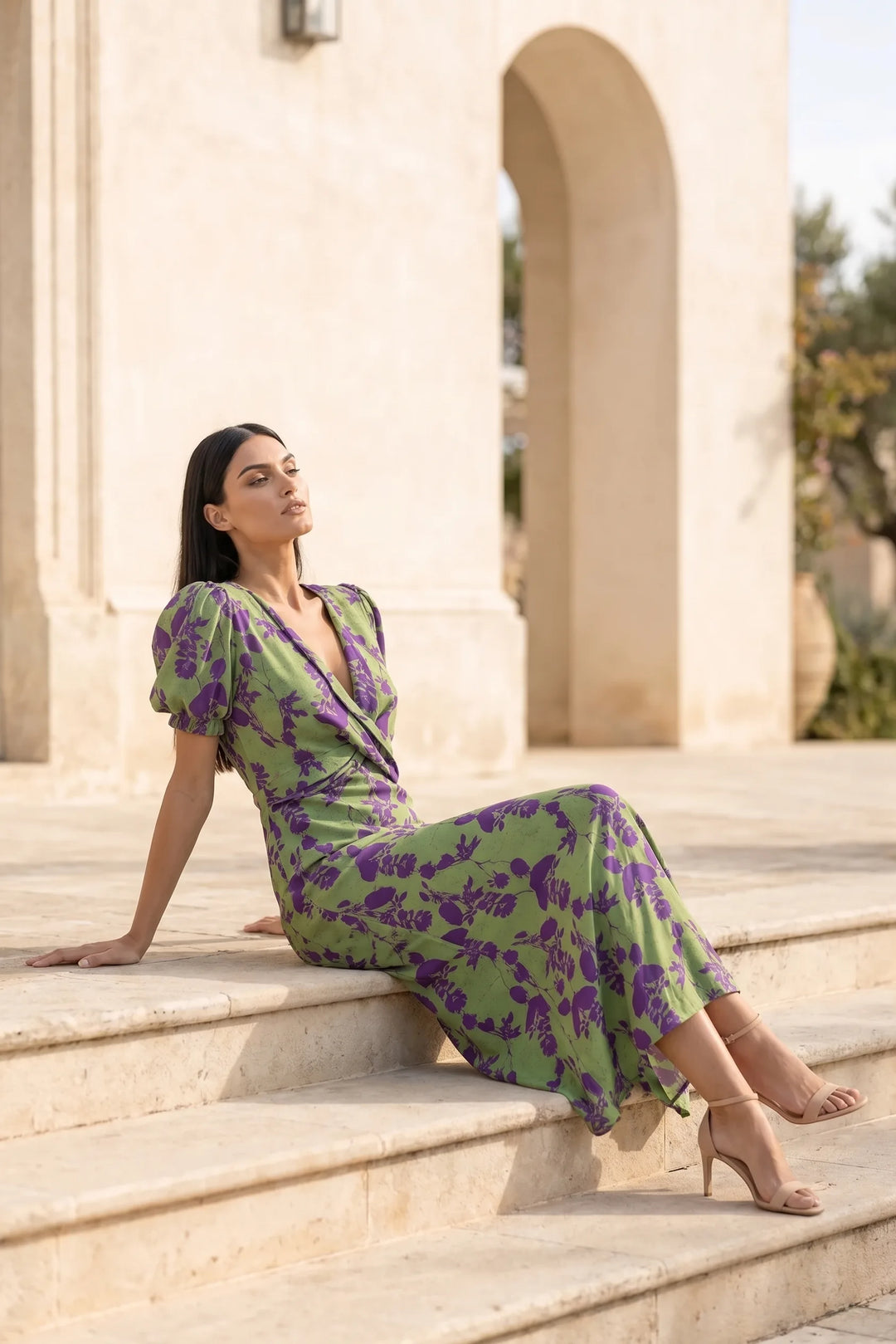 Model in green floral wrap midi dress styled in a casual lifestyle scene