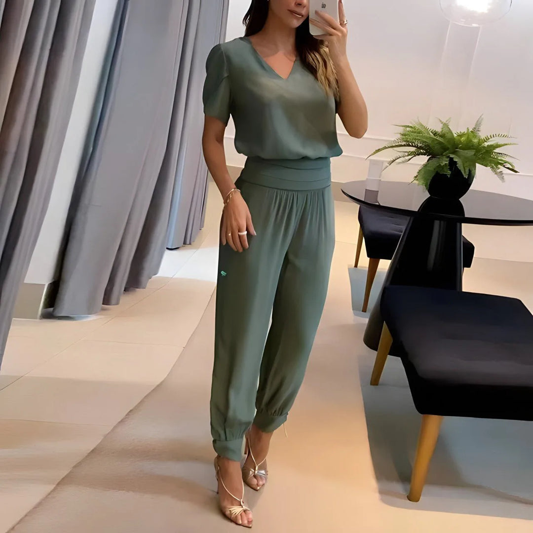 Woman wearing green printed jogger set, standing in a side profile pose