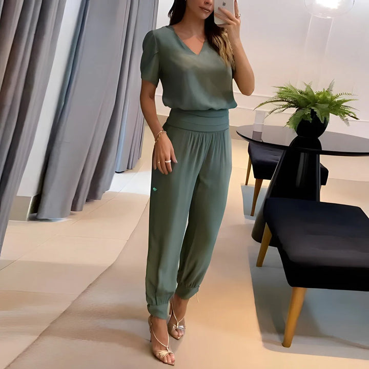 Woman wearing green printed jogger set, standing in a side profile pose