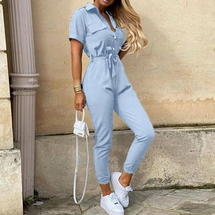 Close-up detail of a light blue striped belted jumpsuit with belt