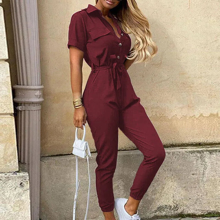 Model in three-quarter turn wearing a red striped belted jumpsuit