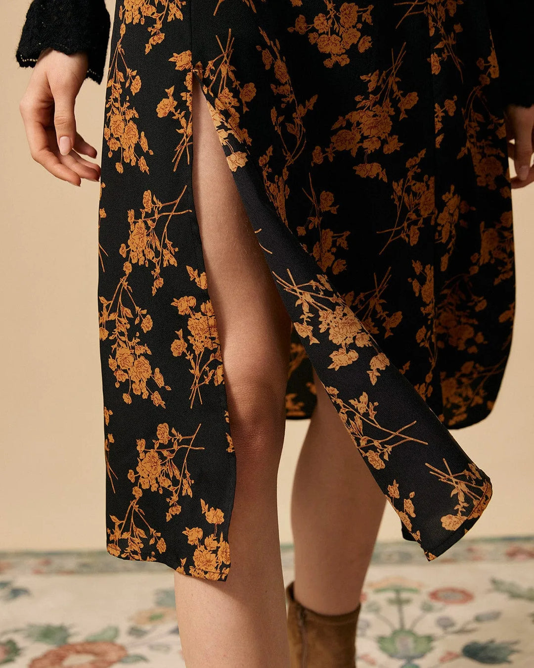 Black floral midi dress with front slit, model in three-quarter turn pose