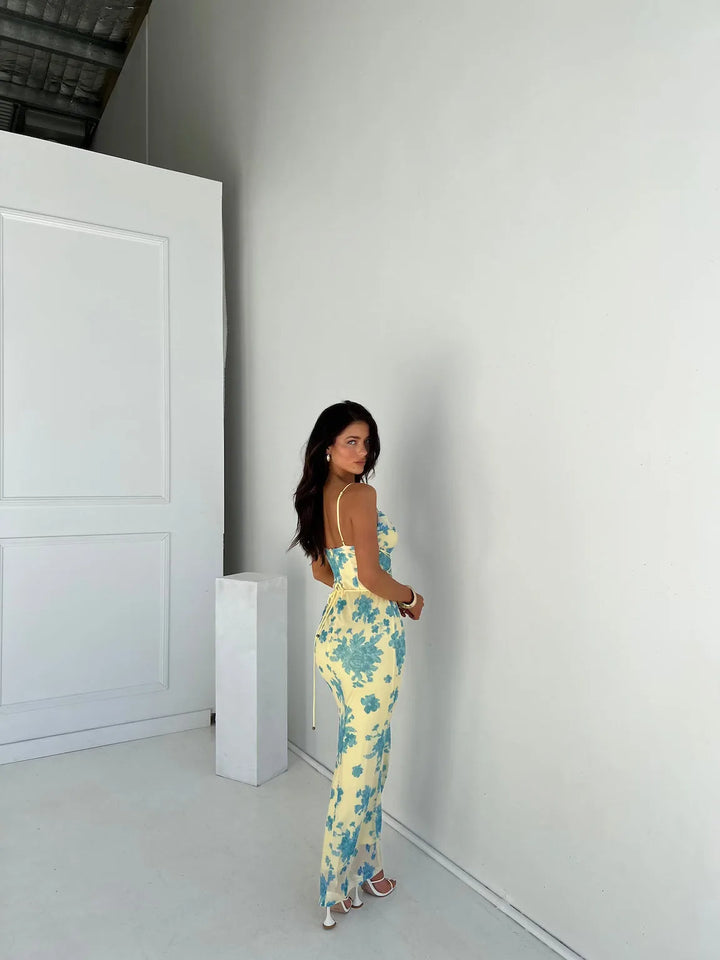 Close-up detail of the floral print and lace-up bodice on a yellow and blue maxi dress