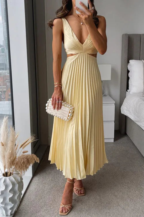 Woman wearing a yellow pleated midi dress with cutout detail, facing forward