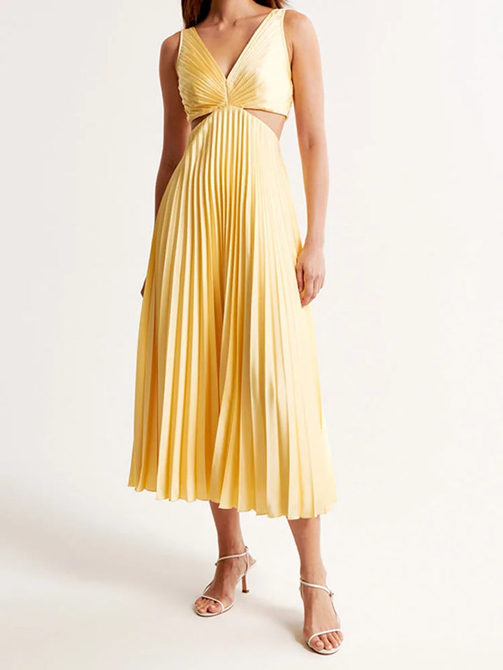 Woman in a yellow pleated cutout midi dress shown from the side