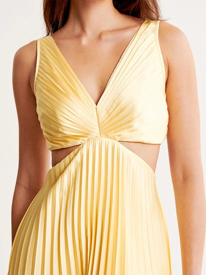 Woman styled in a yellow pleated cutout midi dress, full-length view