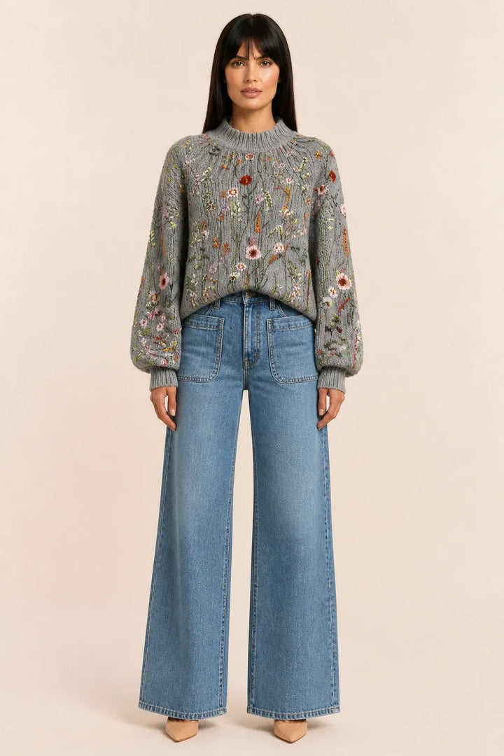 Multicolor embroidered floral knit top worn by a model in a contrapposto stance