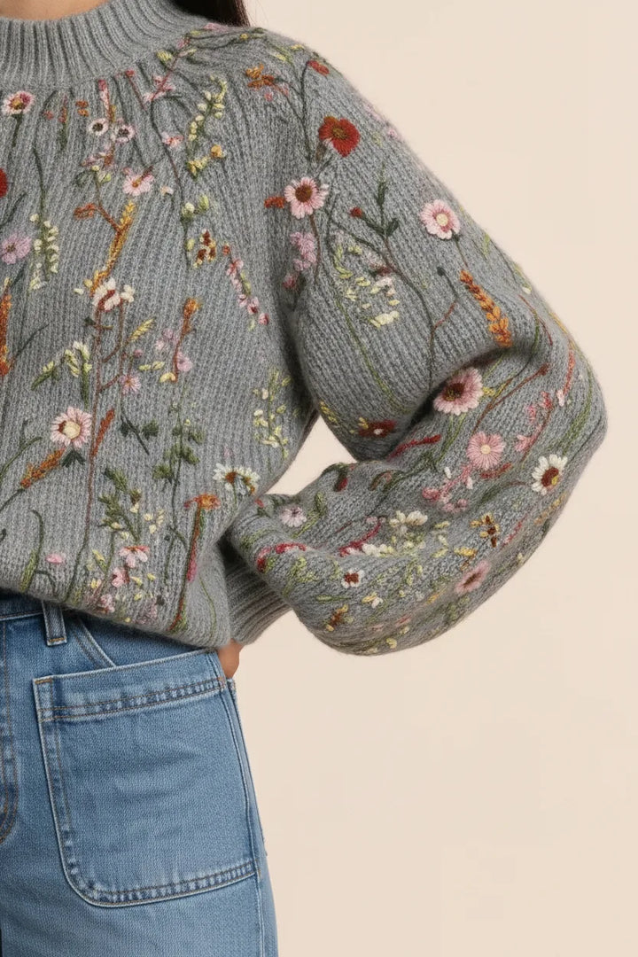 Close-up detail of multicolor embroidered floral pattern on a knit top