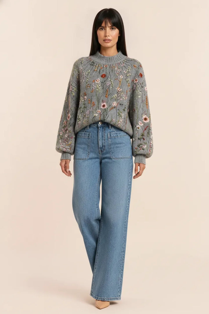 Multicolor embroidered floral knit top displayed on a model outside a storefront
