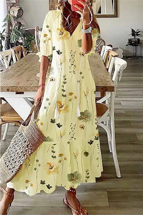 Yellow boho maxi dress with tassel hem, model in three-quarter turn