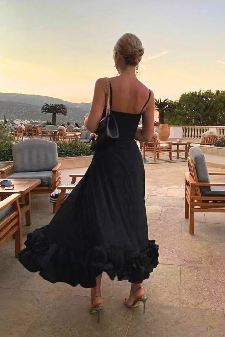 Model in side profile wearing a black ruffle hem midi dress showing silhouette