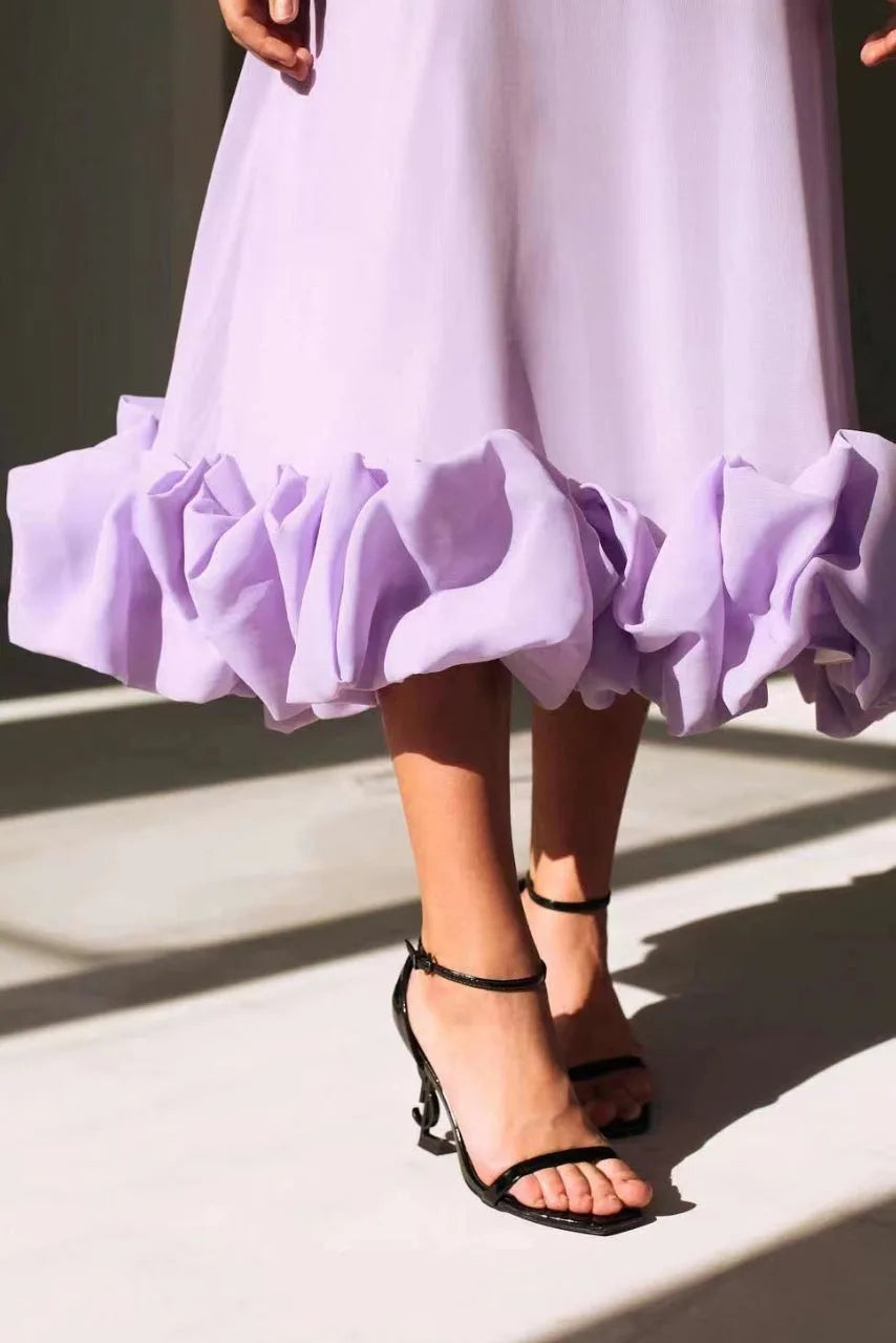 Model wearing a black ruffle hem midi dress in an alternate styling view