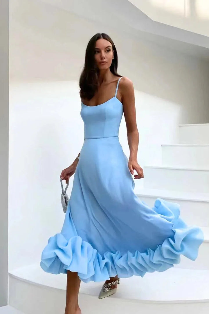 Model at a three-quarter turn in a blue ruffle hem midi dress